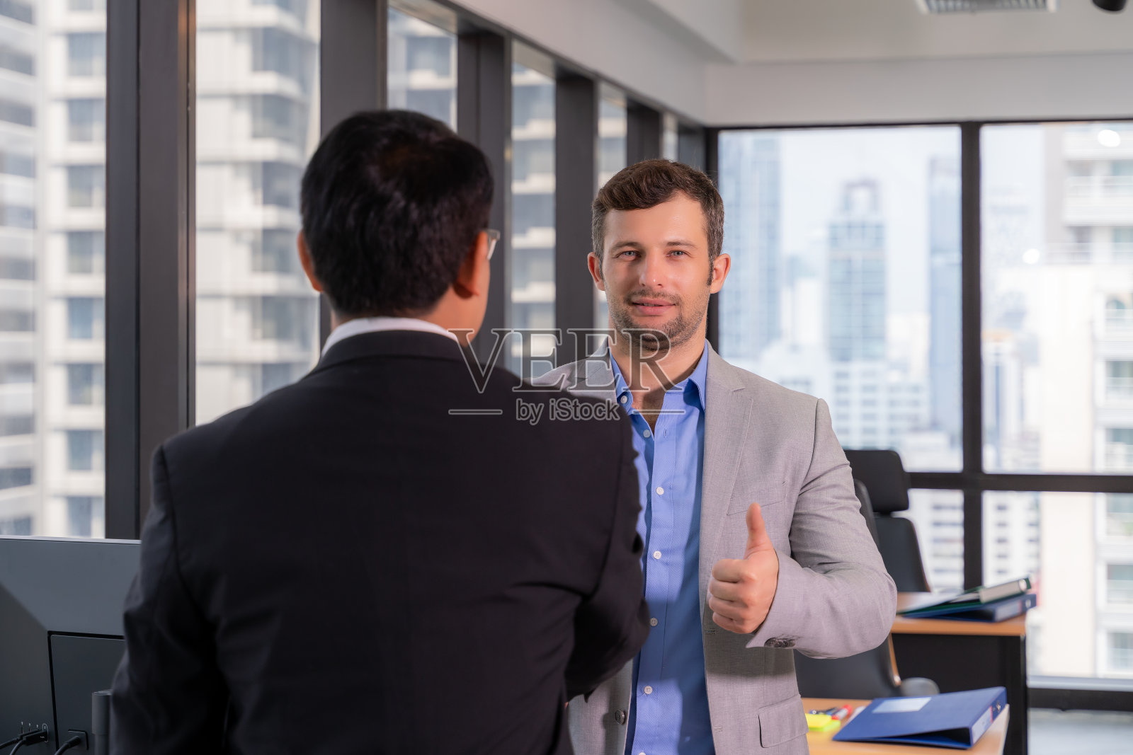 一群年轻的商业人士坐在一起工作和交流。照片摄影图片