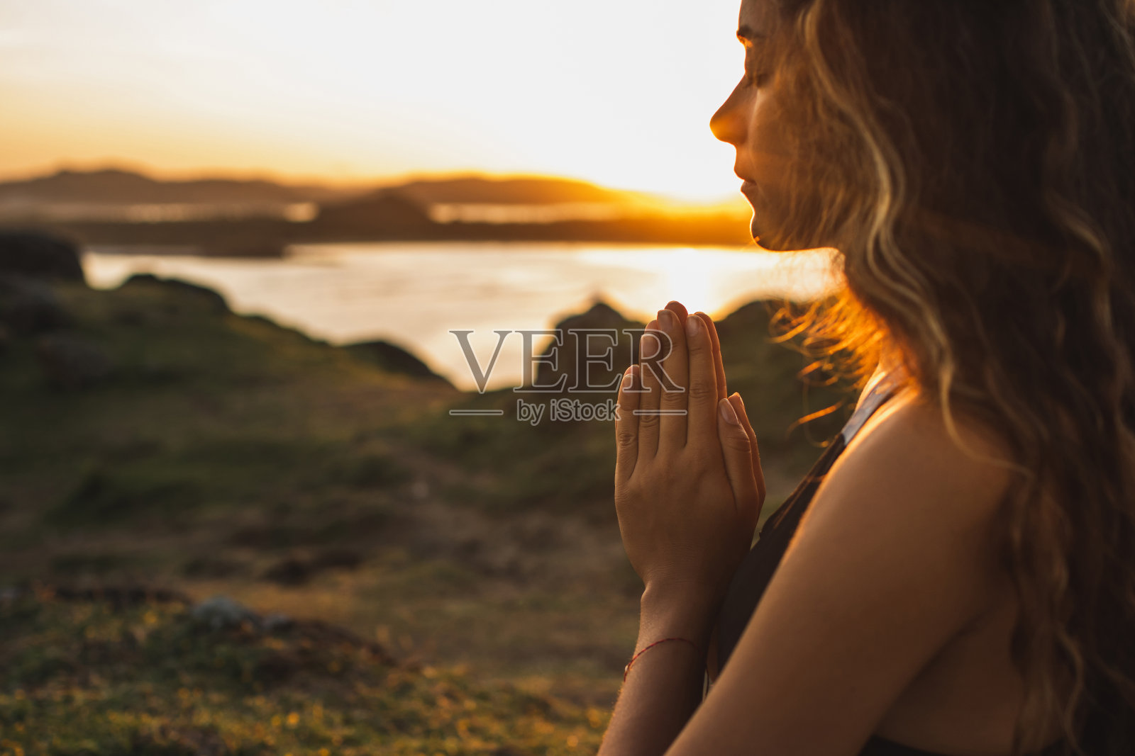 在日出时独自祈祷的女人。自然背景。精神和情感的概念。对自然的敏感性照片摄影图片