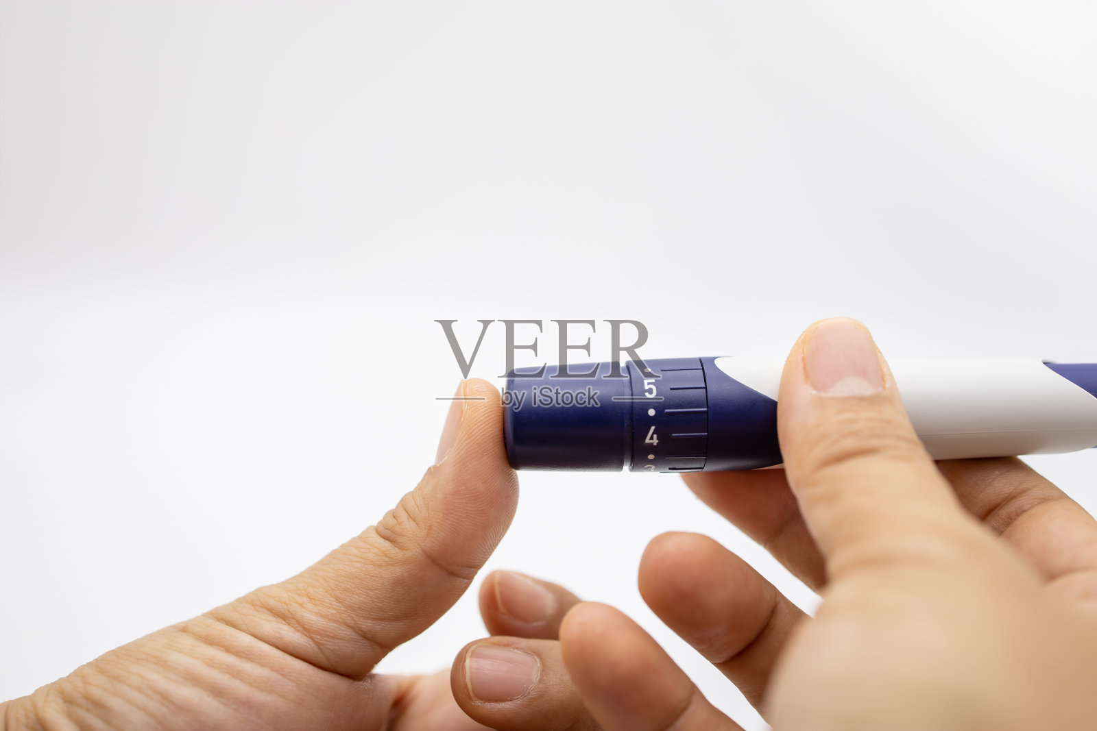 特写妇女的手用刺针在手指上检查血糖水平的血糖仪。用作医药，降糖，降血糖，保健和人的理念。照片摄影图片