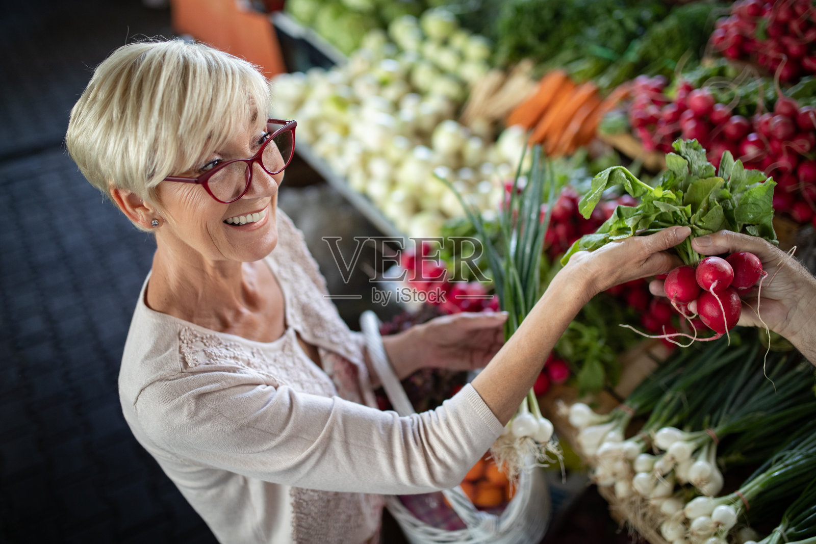 一位老妇人在绿色市场买菜。照片摄影图片