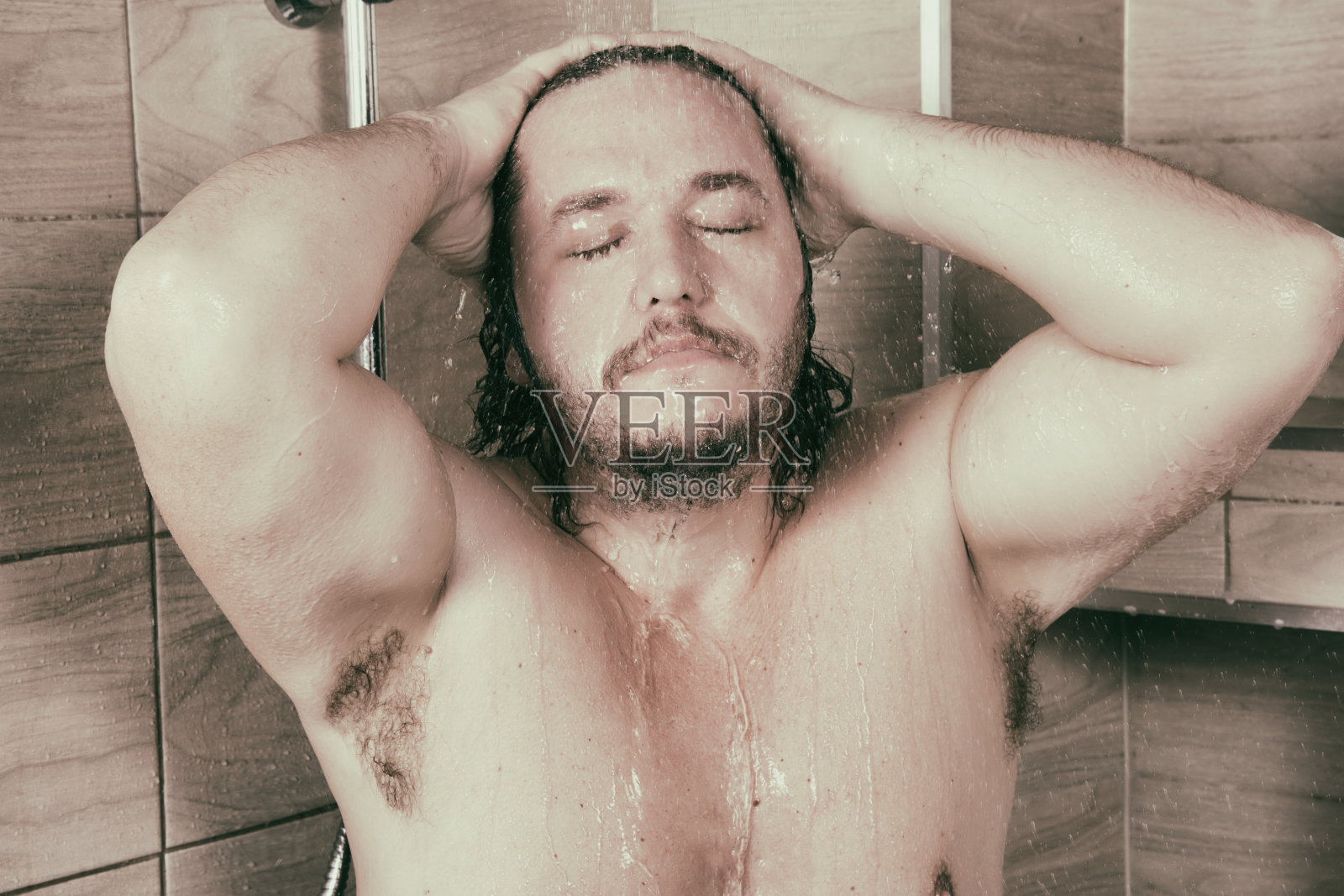 残忍的男人在淋浴时洗澡。照片摄影图片