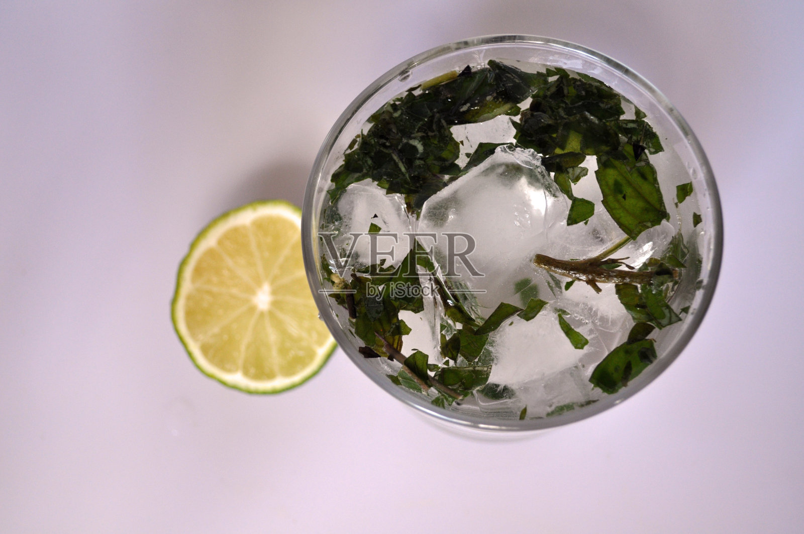 一杯有薄荷、冰和酸橙的清澈液体照片摄影图片