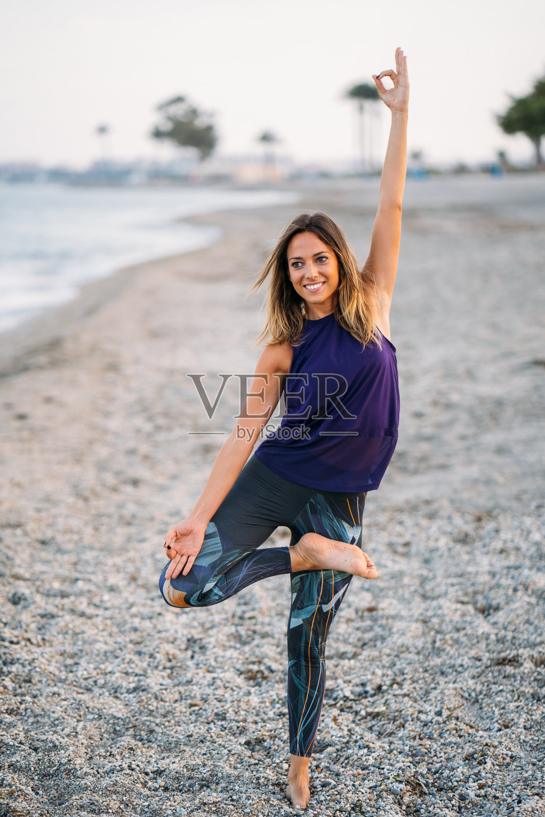 年轻健康的瑜伽女性在日出时在海滩上练习瑜伽姿势，有利于身体、精神、健康、放松的自然环境理念。照片摄影图片