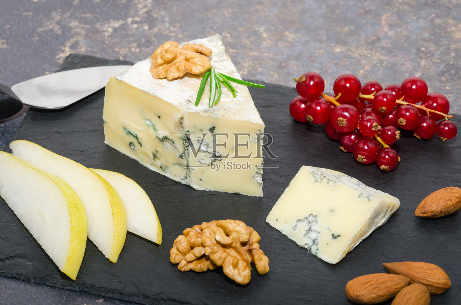 蓝纹芝士配梨片、杏仁片、核桃片和红醋栗片。照片摄影图片