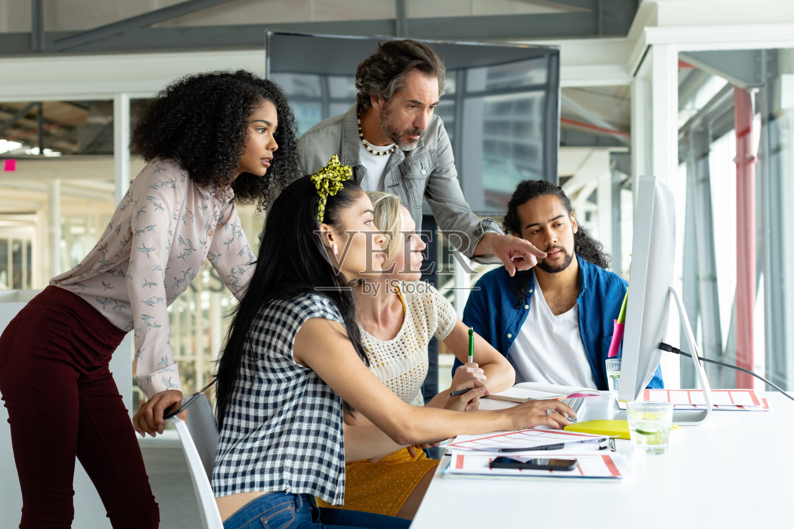 商务人员在一个现代化的办公室的会议室里一起在电脑上工作照片摄影图片