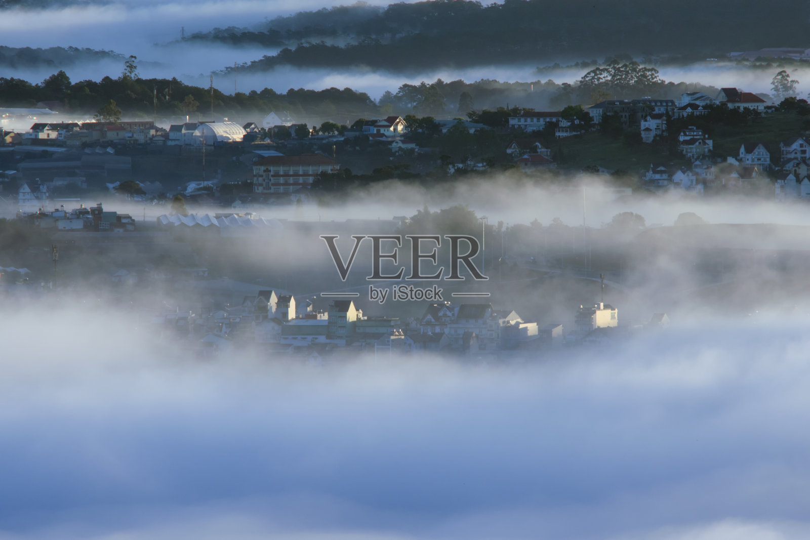 大雾笼罩着越南的大叻高原土地，背景中有着神奇的浓雾和阳光，黎明时分的阳光照片摄影图片