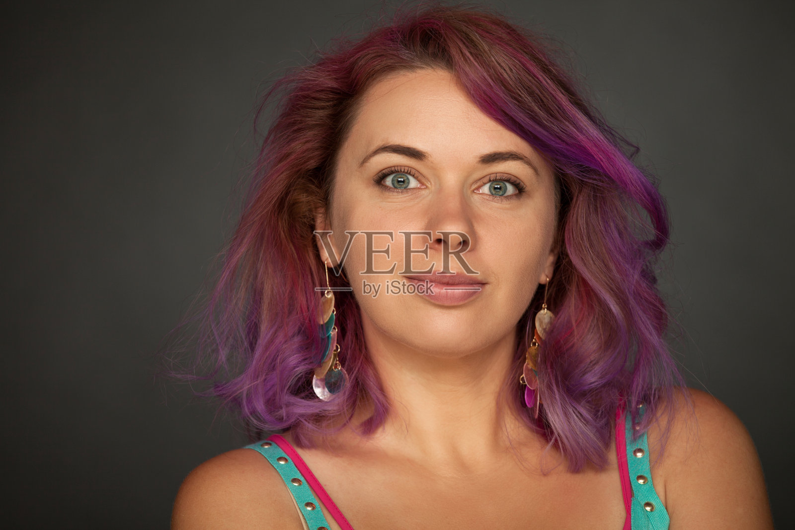 一个30岁的女人的工作室肖像与紫色的头发在一个黑色的背景照片摄影图片