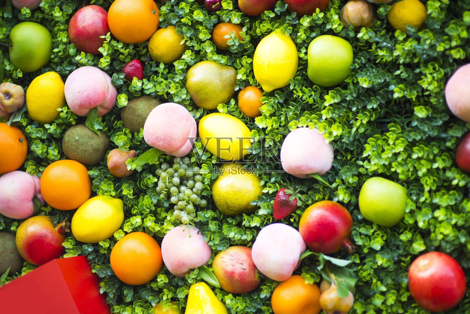 在绿色背景下的水果组合。由新鲜水果制成的图案。俯视图，平面设计。李子、葡萄、苹果、花、油桃的拼贴画。照片摄影图片