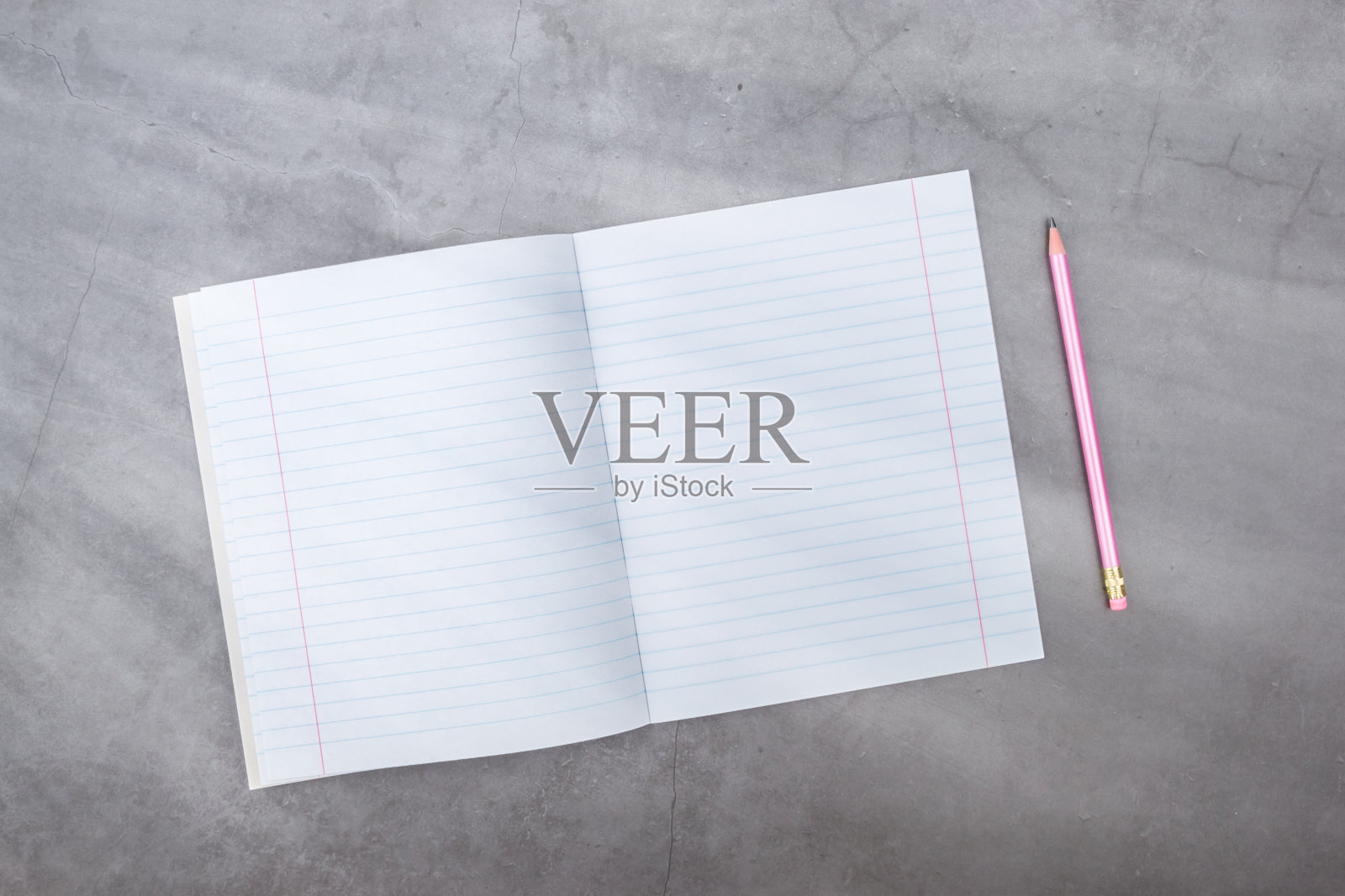 平躺，俯视图，笔记本，铅笔在一个灰色纹理的背景。光线从侧面照过来。照片摄影图片