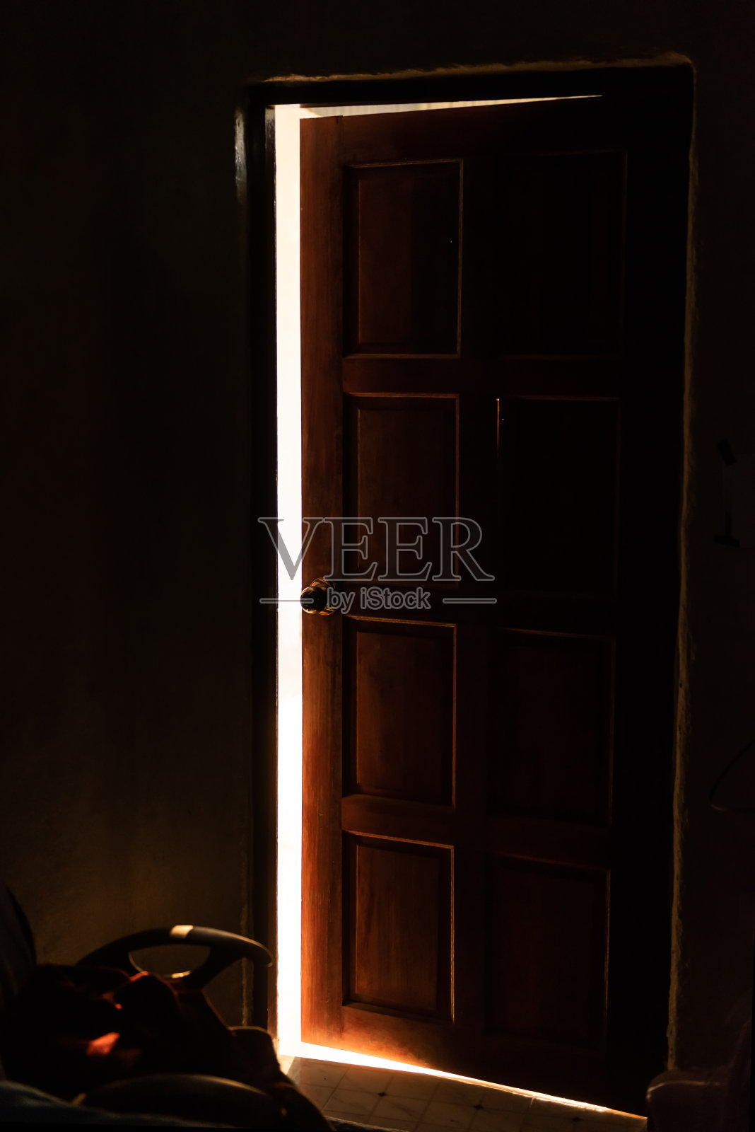 明亮温暖的光线从一扇打开的门中漏出来照片摄影图片