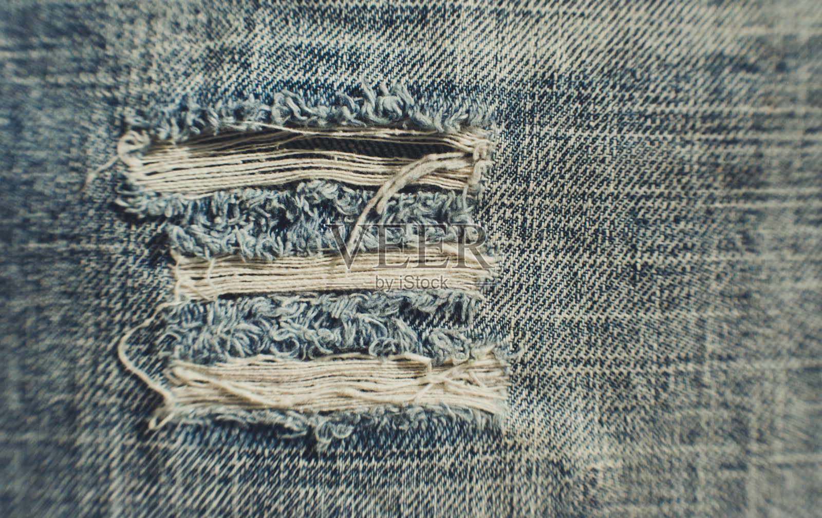 有洞的经典美国牛仔布。棉布质地照片摄影图片