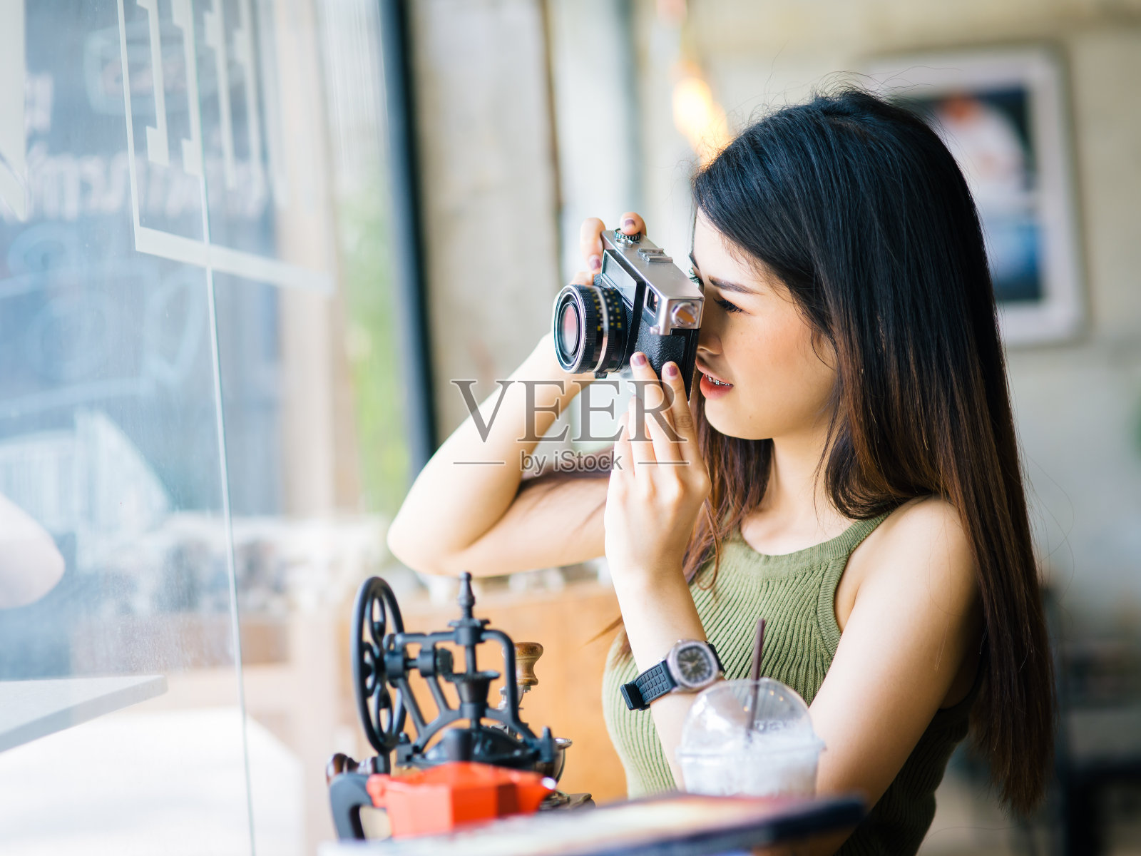 快乐的亚洲女人拿着老式相机在咖啡馆，生活方式的概念。照片摄影图片