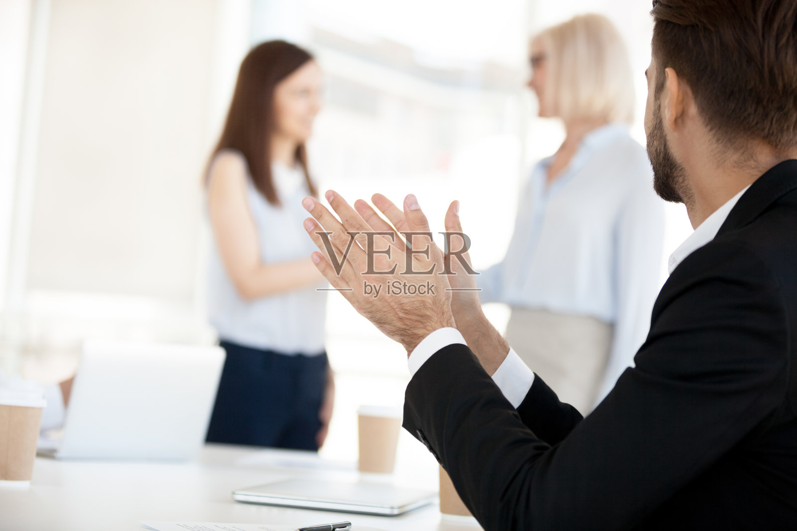 商人在公司会议上鼓掌，祝贺同事照片摄影图片