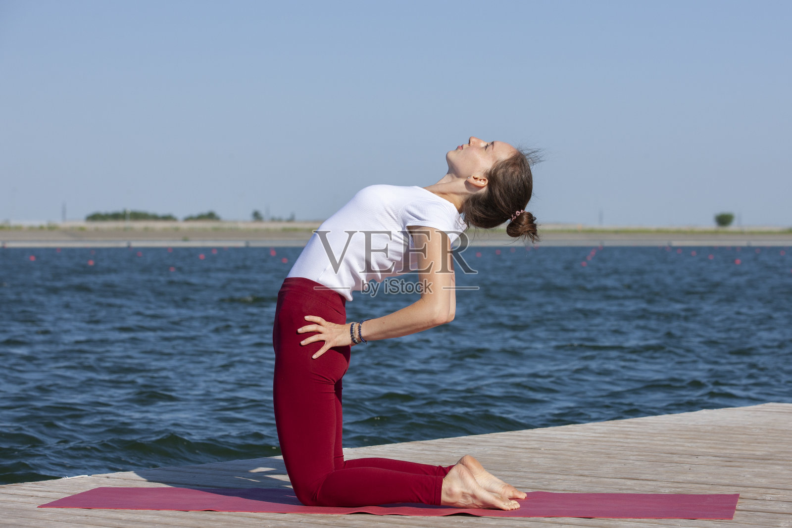 健康的生活方式在自然，妇女做瑜伽运动在公园附近的湖。照片摄影图片