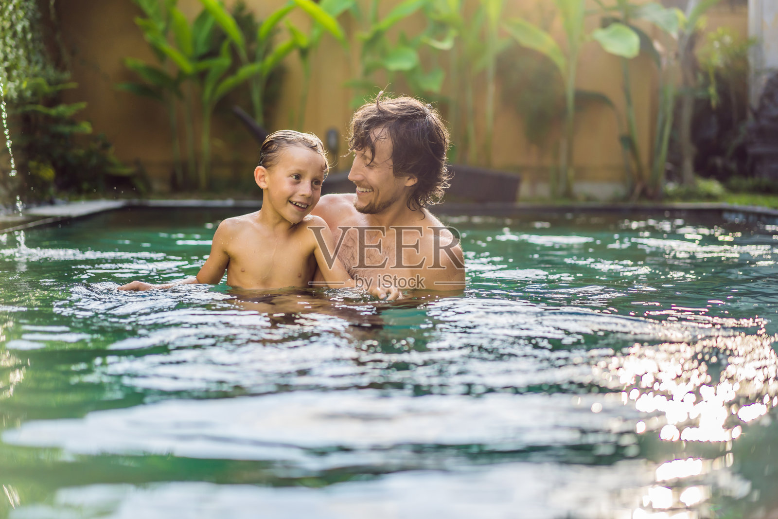 爸爸和儿子在游泳池里玩得很开心照片摄影图片