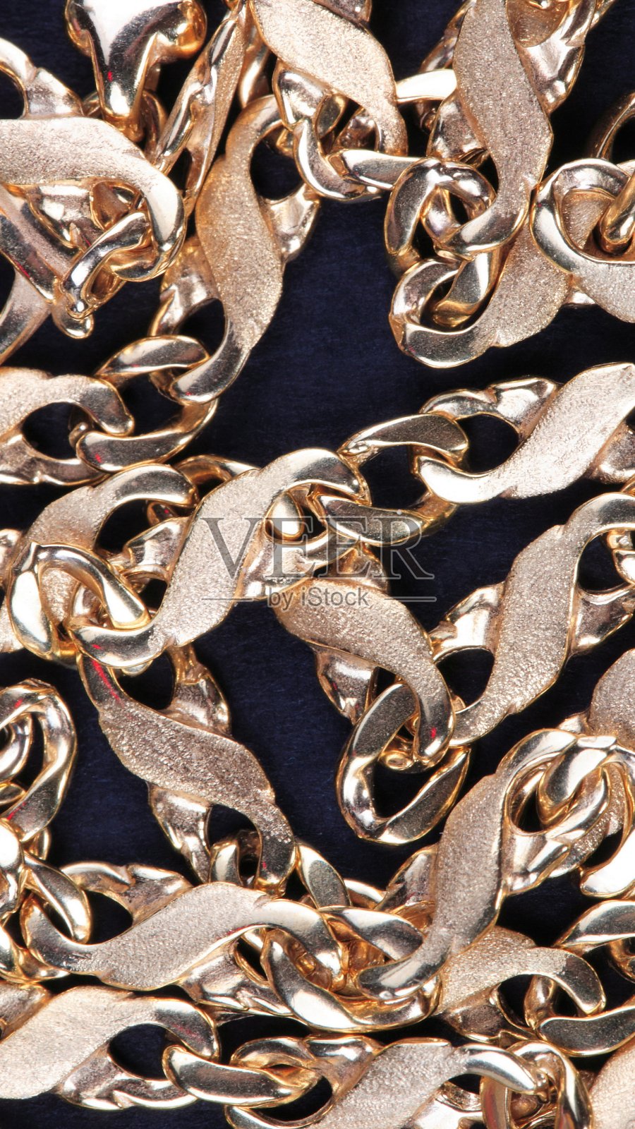 黑色织物上的黄色金链照片摄影图片