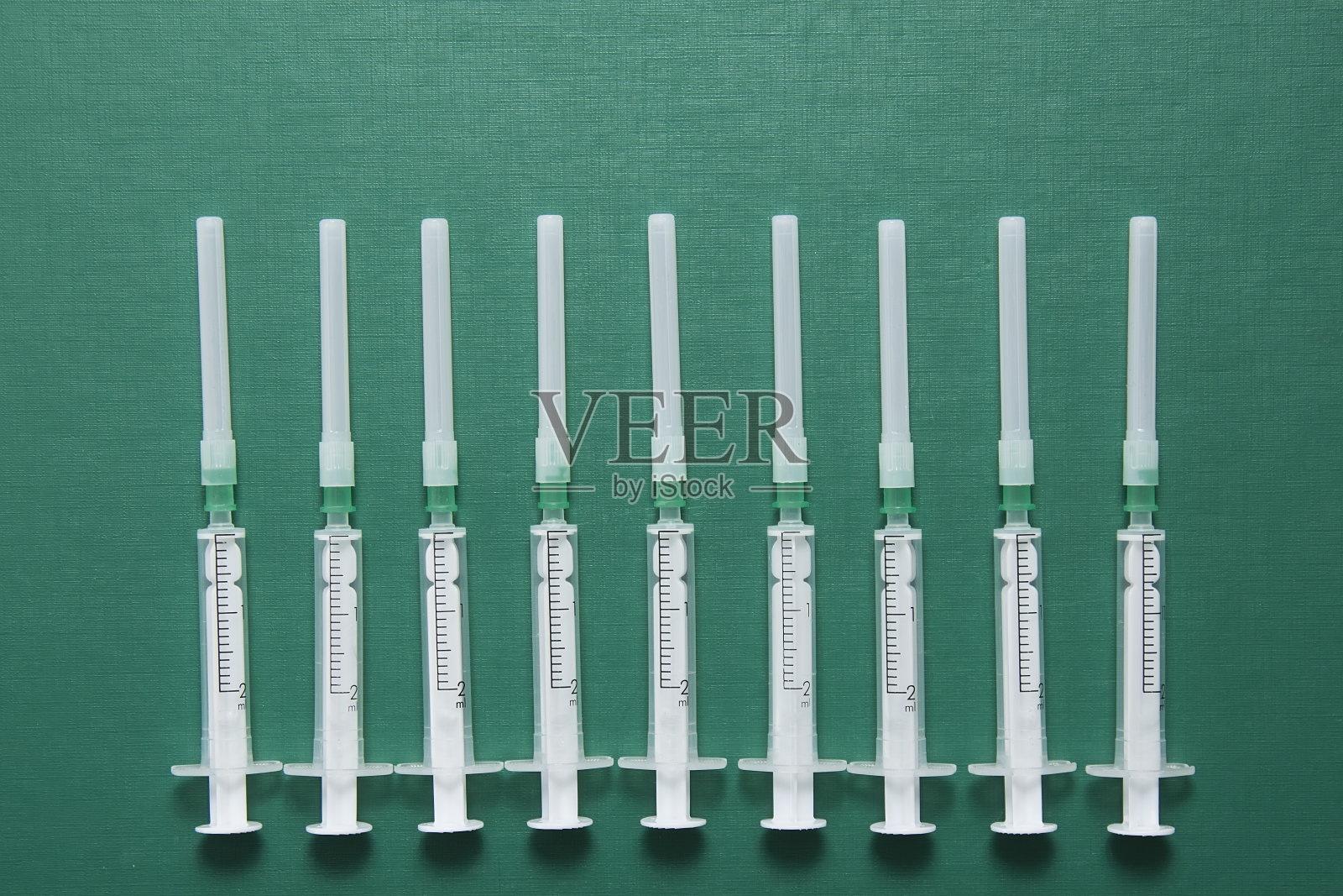 绿色背景上的一次性注射器照片摄影图片