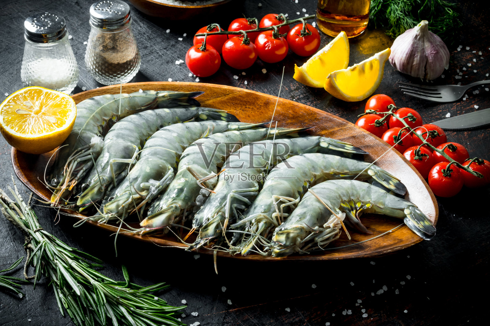 鲜虾配樱桃番茄，大蒜和柠檬片。照片摄影图片