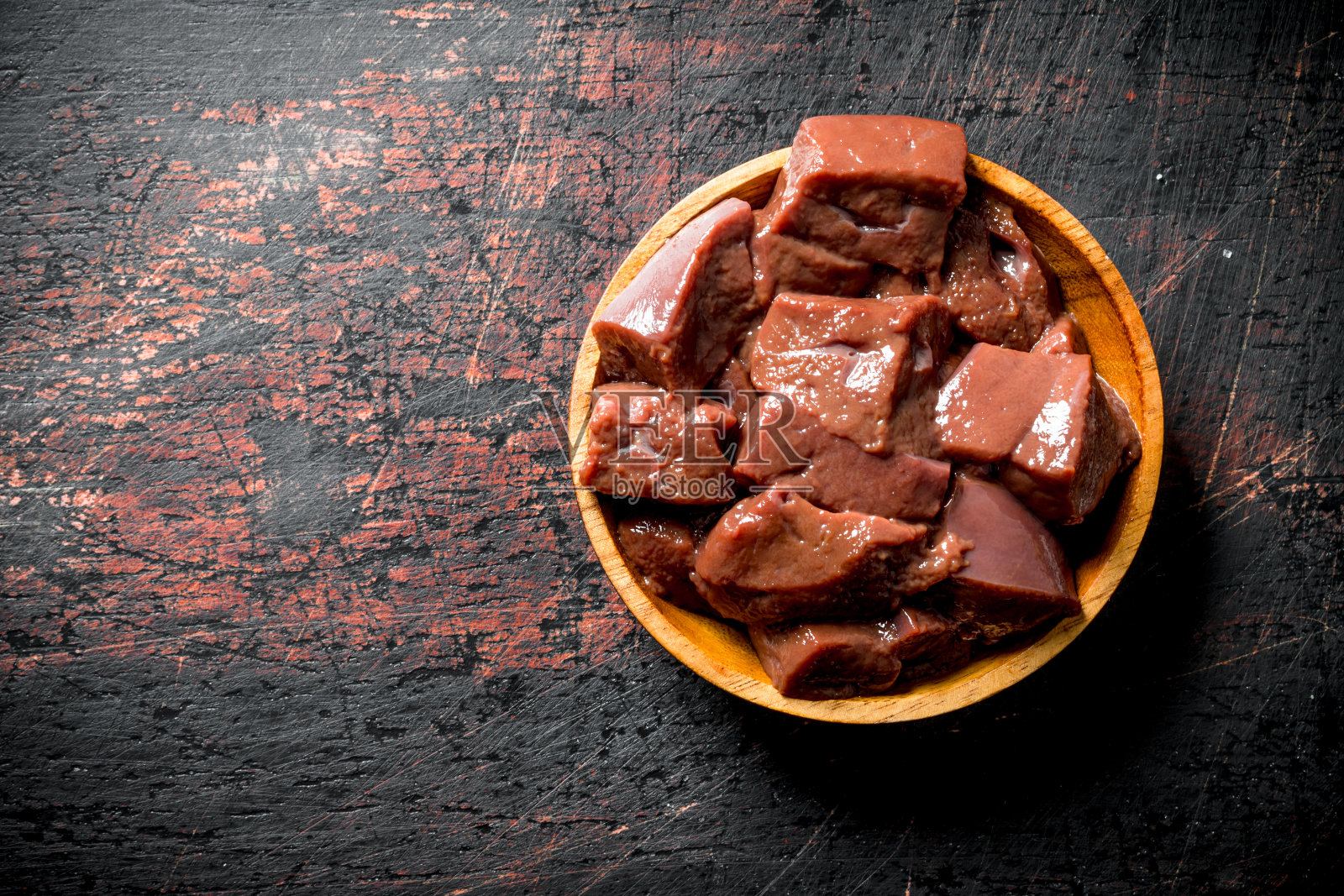 把新鲜的肝片放在碗里。照片摄影图片