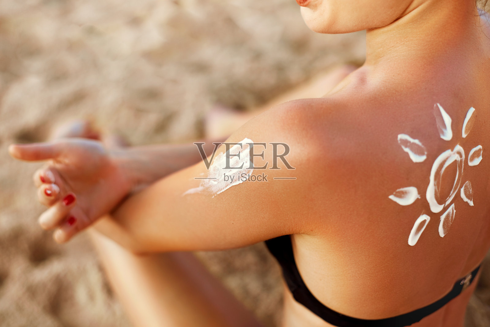 美丽的女人微笑着在肩膀上涂防晒霜。护肤品。身体防晒。防晒霜。皮肤保护和皮肤科照片摄影图片