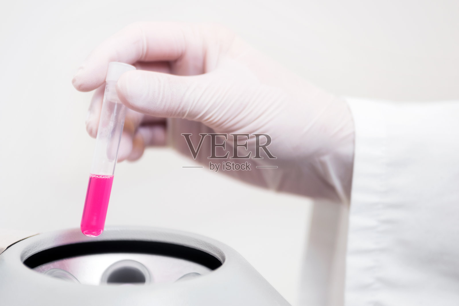 科学家将试管放入离心机。照片摄影图片