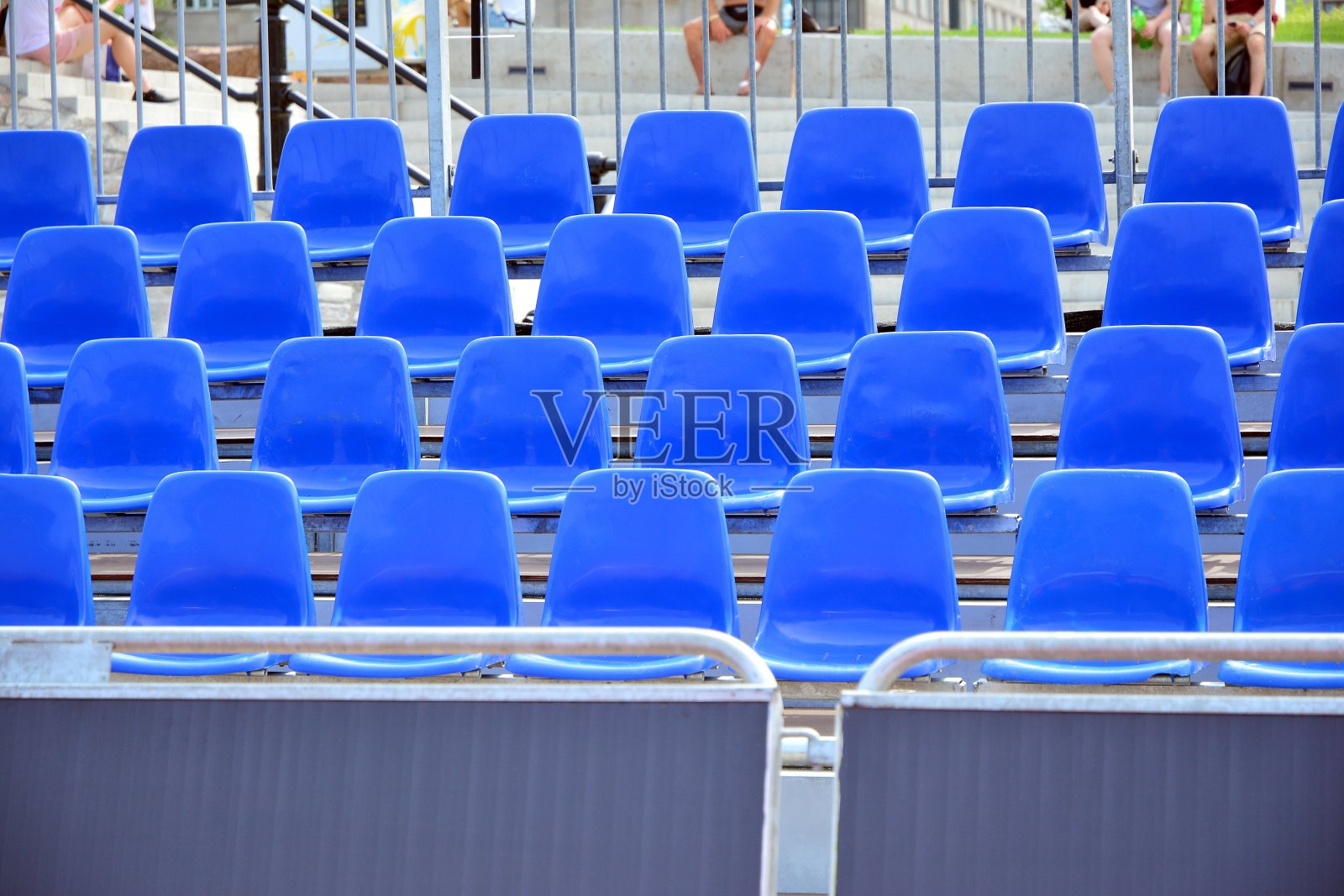 足球场上一排空的蓝色塑料椅子照片摄影图片