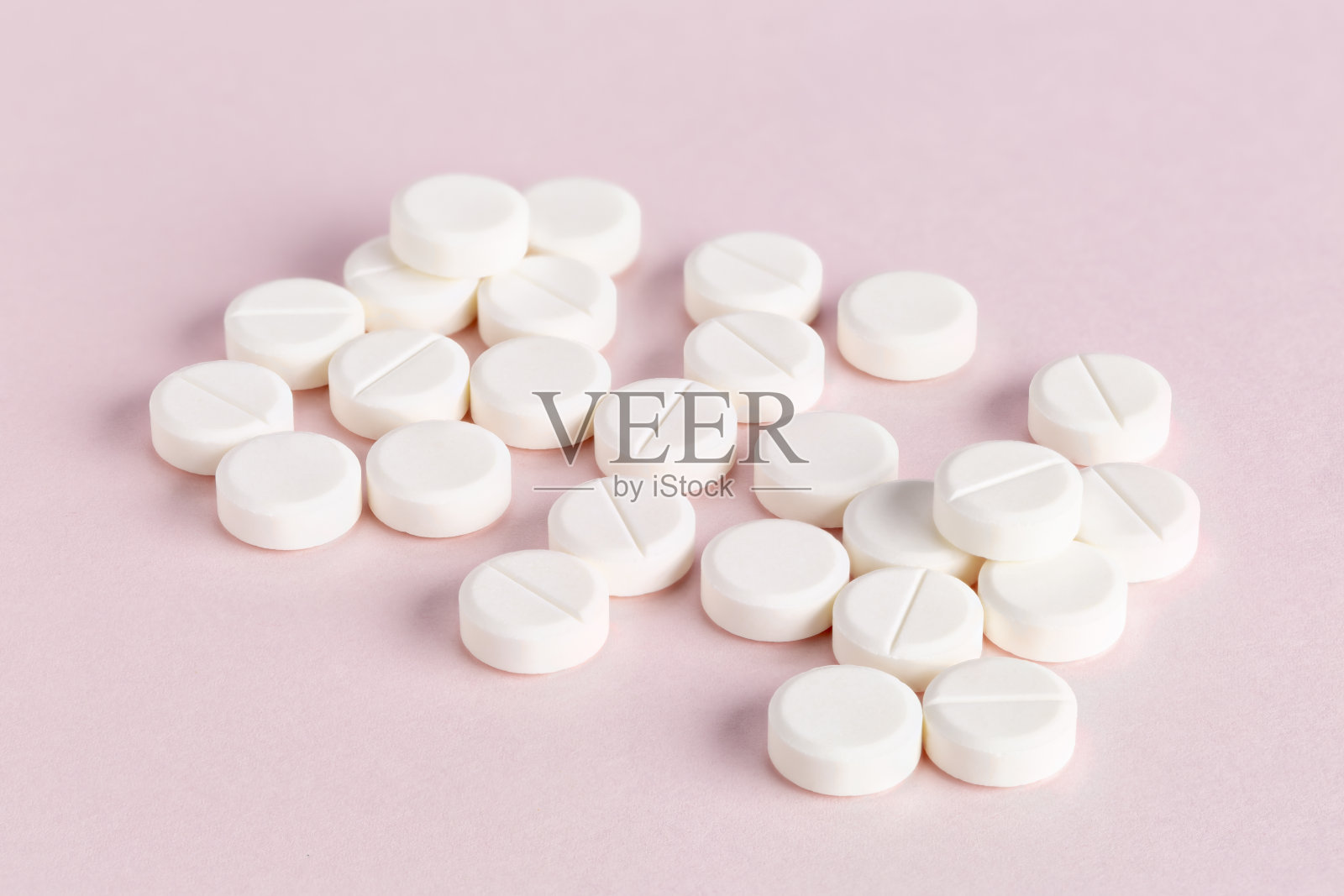 粉红色背景上的圆形药丸照片摄影图片