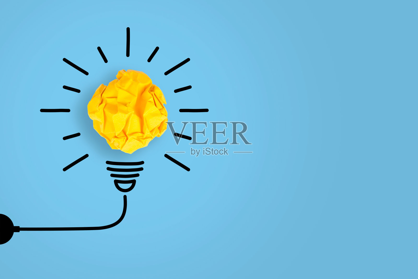 蓝色背景上的皱巴巴的黄纸灯泡照片摄影图片