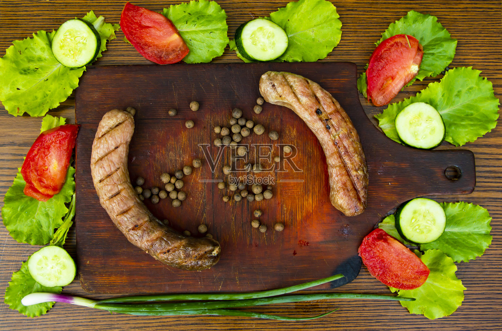 切菜板上的巴伐利亚香肠和蔬菜。照片摄影图片