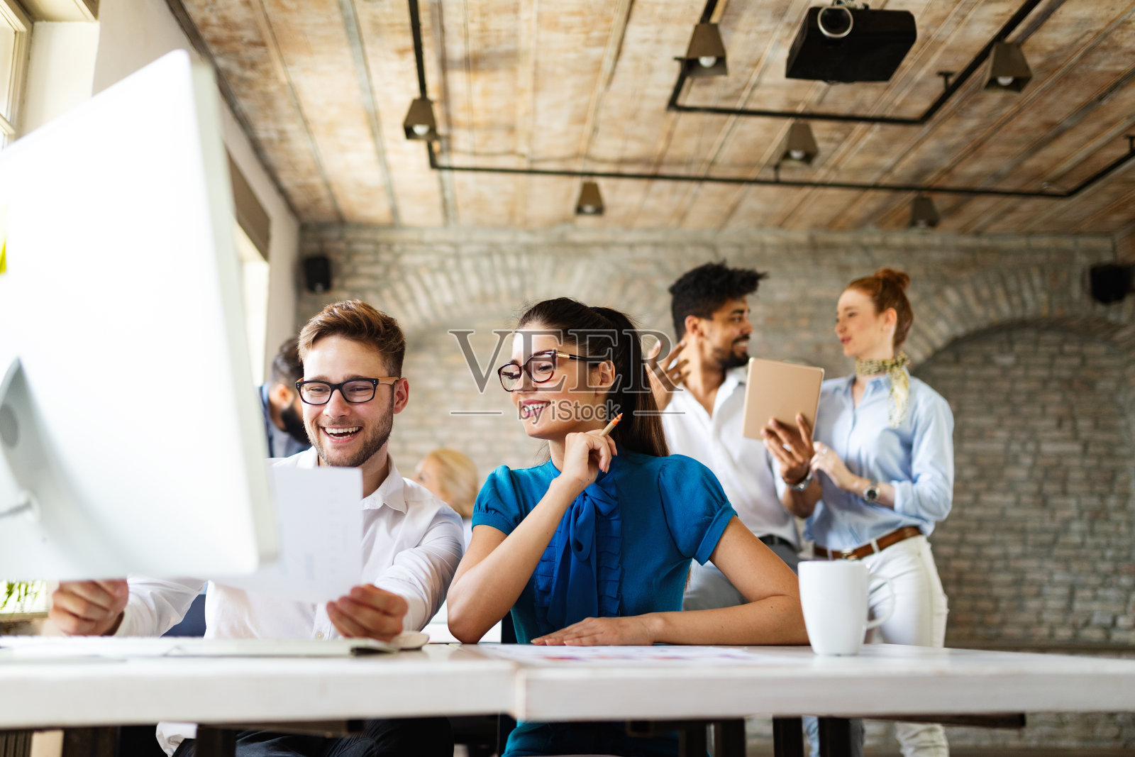 一群正在开会的商务人士。各式各样的设计师在办公室微笑。照片摄影图片