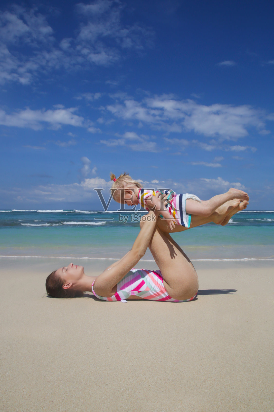 妈妈和她的宝贝女儿一起做瑜伽运动，户外家庭活动，家庭暑假概念照片摄影图片