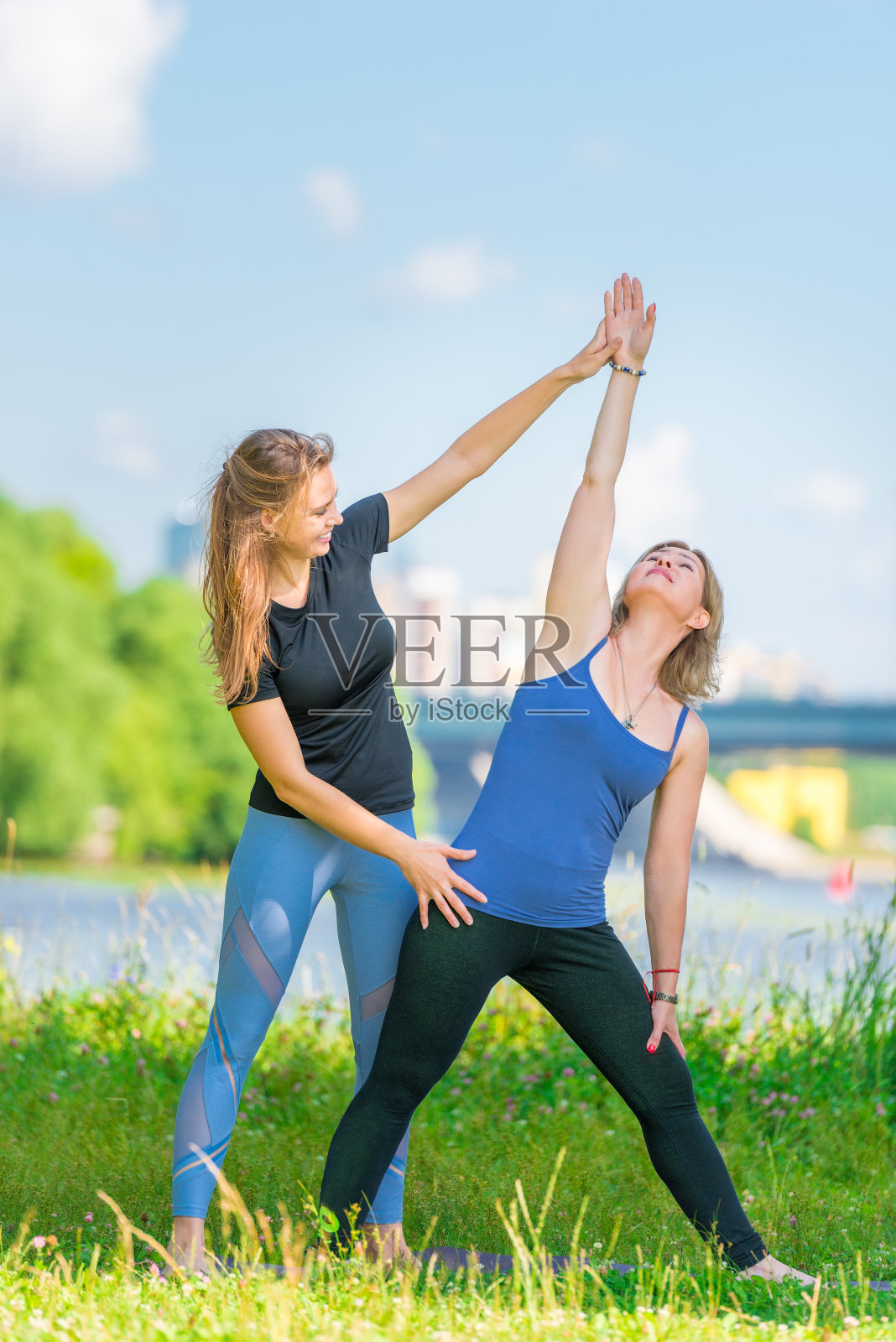 在公园里有一个年轻有经验的教练为你上瑜伽课照片摄影图片