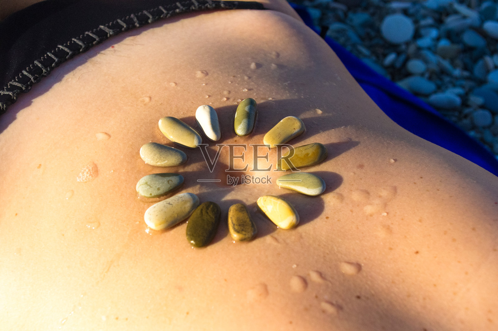 图案小的海石在女人的皮肤上，卵石滩照片摄影图片