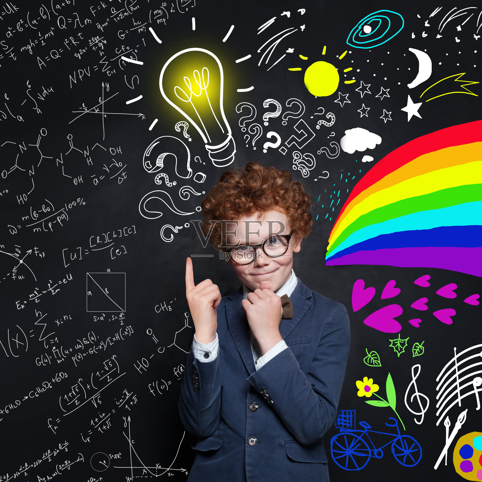 可爱的小男孩一边思考一边指着灯泡。头脑风暴和想法概念照片摄影图片