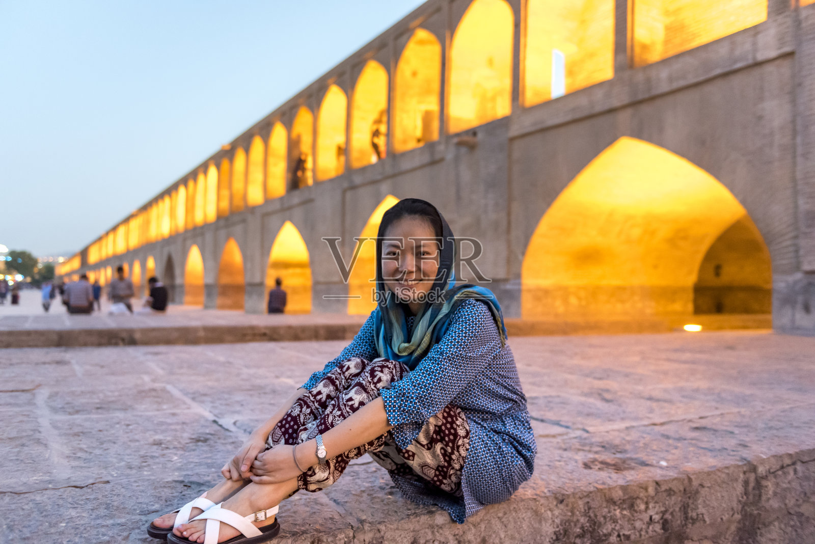 坐在伊斯法罕三十三孔桥的女士照片摄影图片