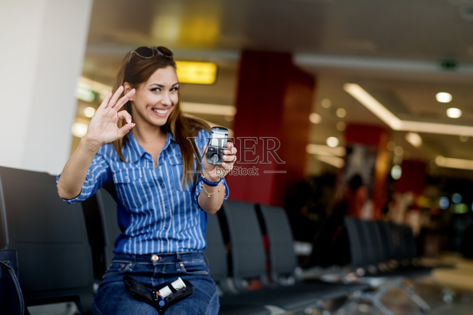 快乐的女人拿着血糖仪，检查血糖水平照片摄影图片