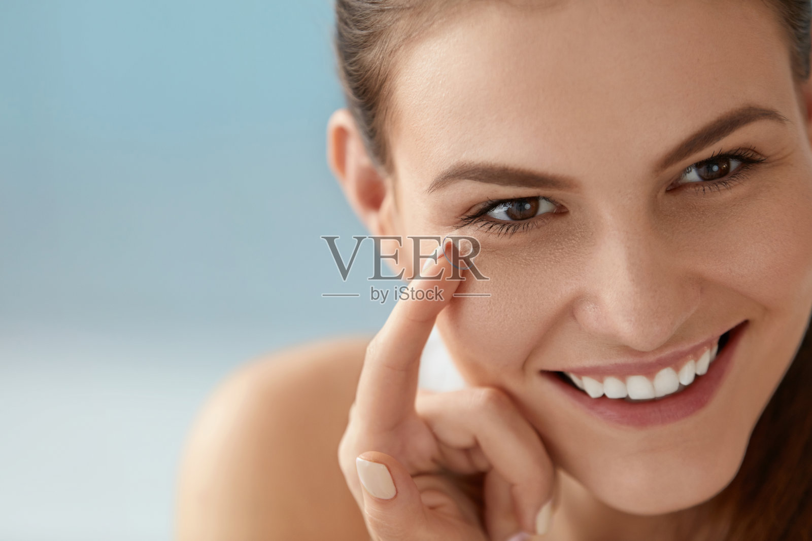 眼部护理。微笑的女人与隐形眼镜在手指特写照片摄影图片