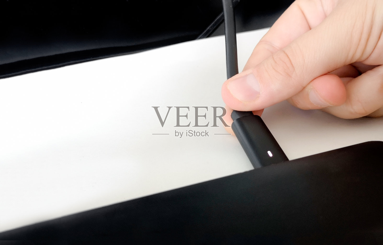 通过连接电源线为笔记本电脑手动充电照片摄影图片