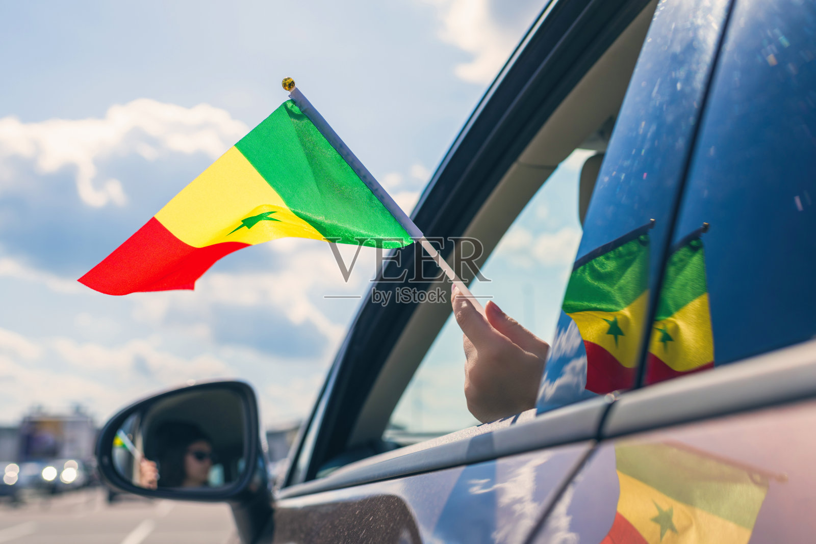 女人或女孩举着塞内加尔国旗从打开的车窗照片摄影图片