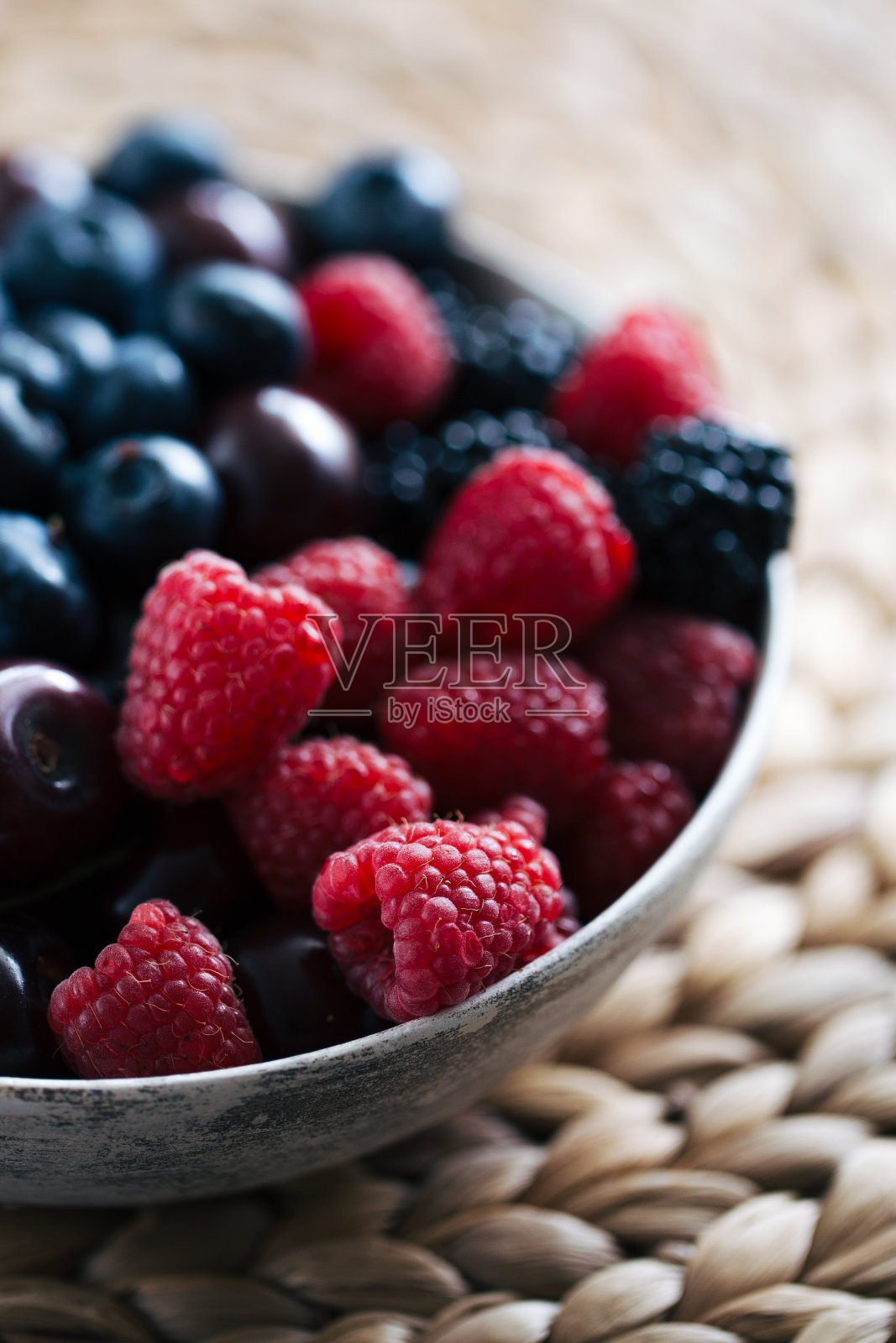夏天的浆果在自然光线下靠近柳条食物垫。照片摄影图片