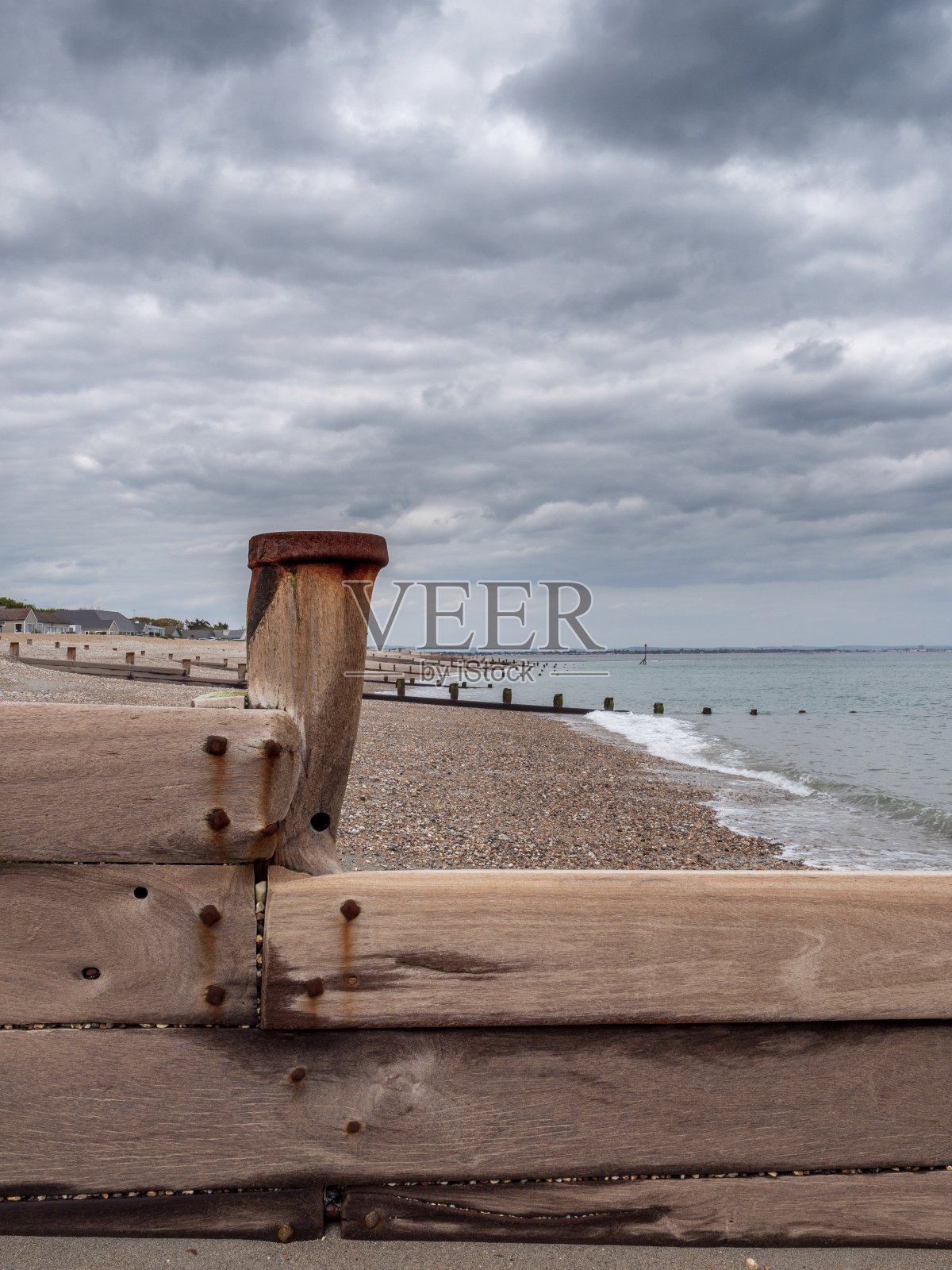 沙坝英格兰南部一个卵石海滩上的破旧和风化的木制防波堤照片摄影图片
