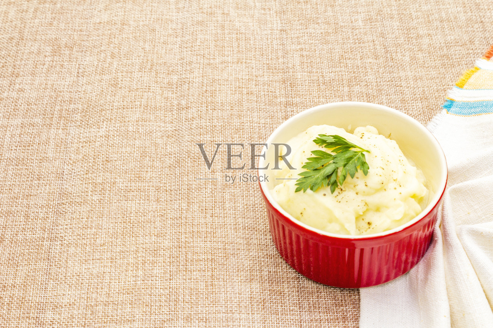 用陶瓷碗加热土豆泥，加入新鲜的欧芹照片摄影图片