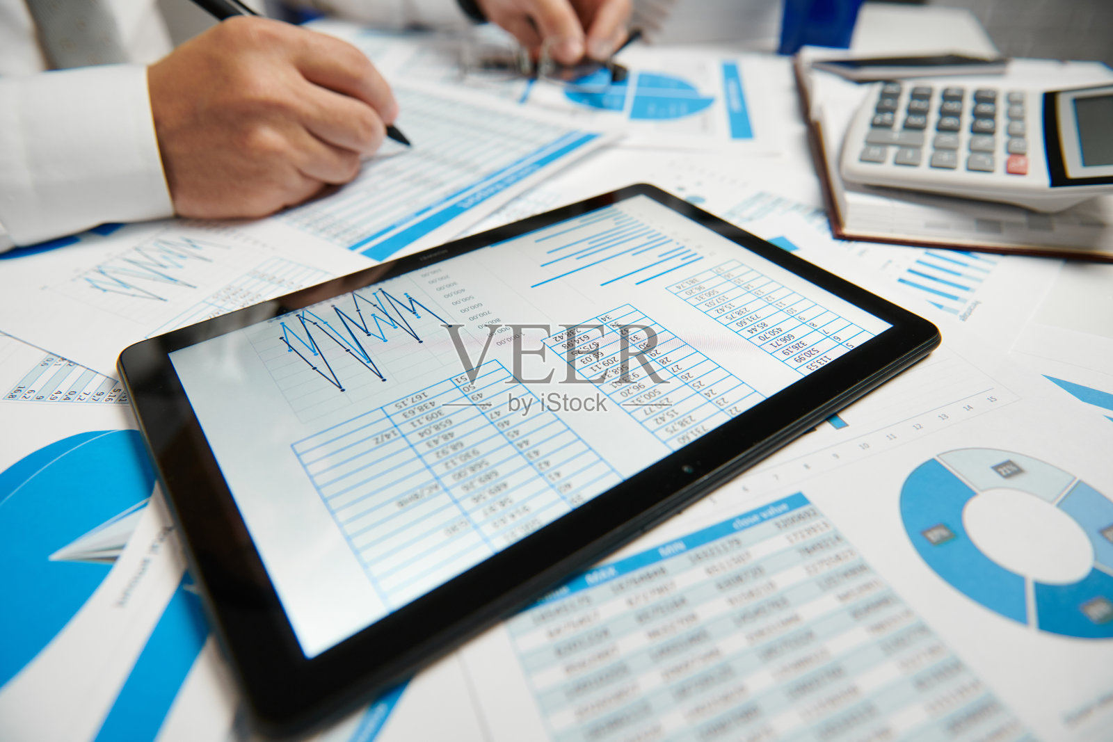 商人工作和计算，读和写报告。使用平板电脑。办公室职员，桌子特写。企业财务会计概念。照片摄影图片