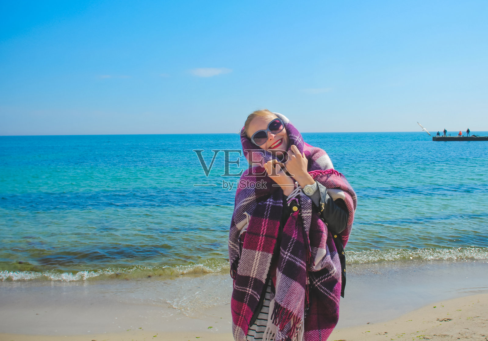 金发女孩在海滩上玩得开心。照片摄影图片