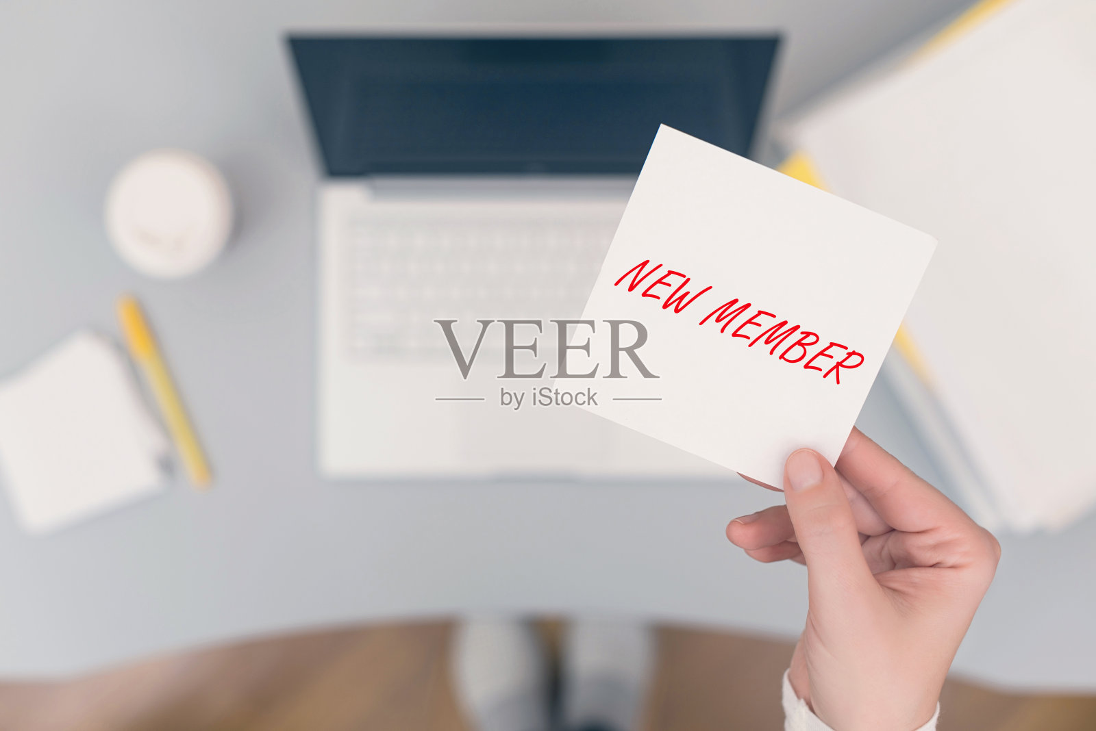 女职员坐着拿着纸条贴着新会员短语。经营理念。的概念。照片摄影图片