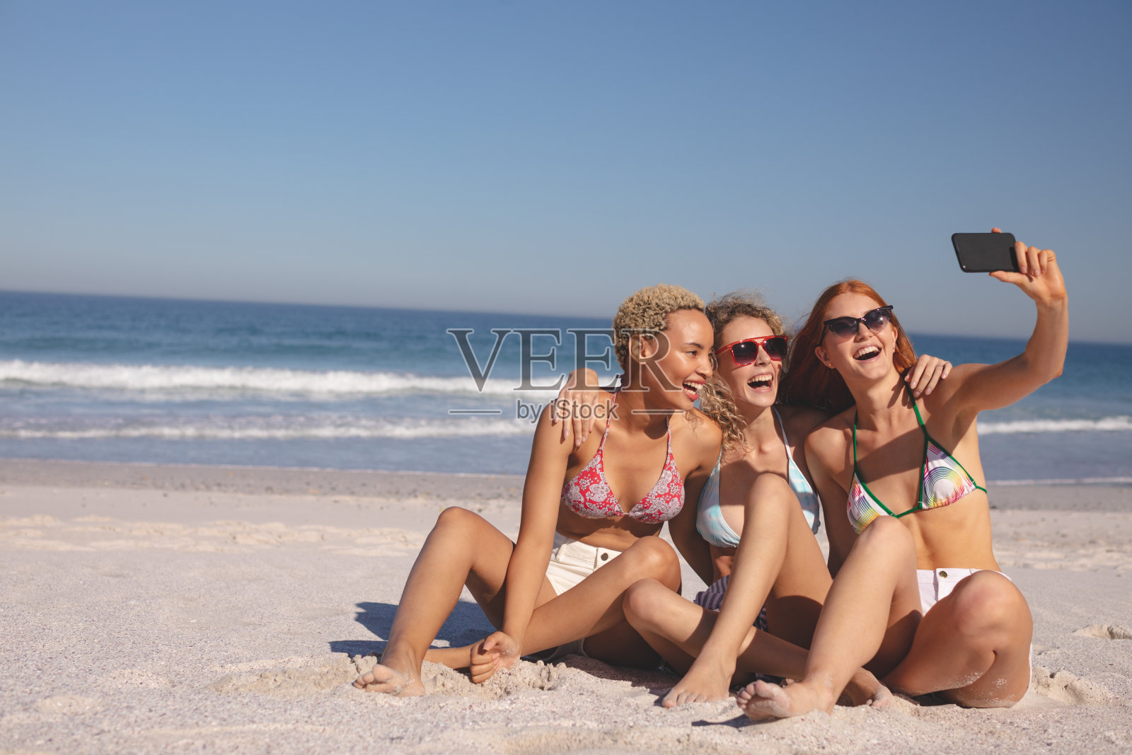 女性朋友在海滩上用手机自拍照片摄影图片