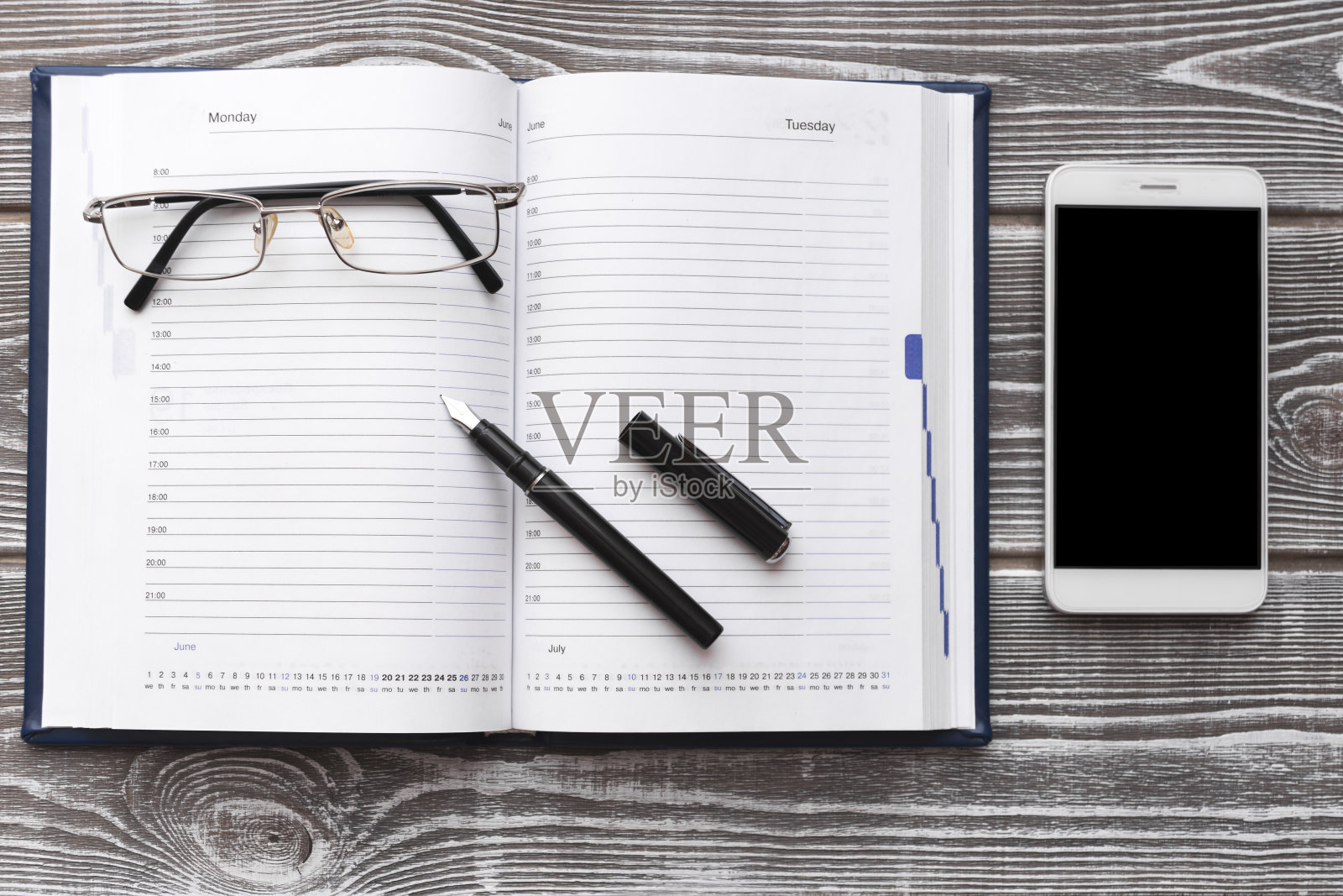 日记，眼镜，钢笔，木质背景黑屏智能手机。照片摄影图片