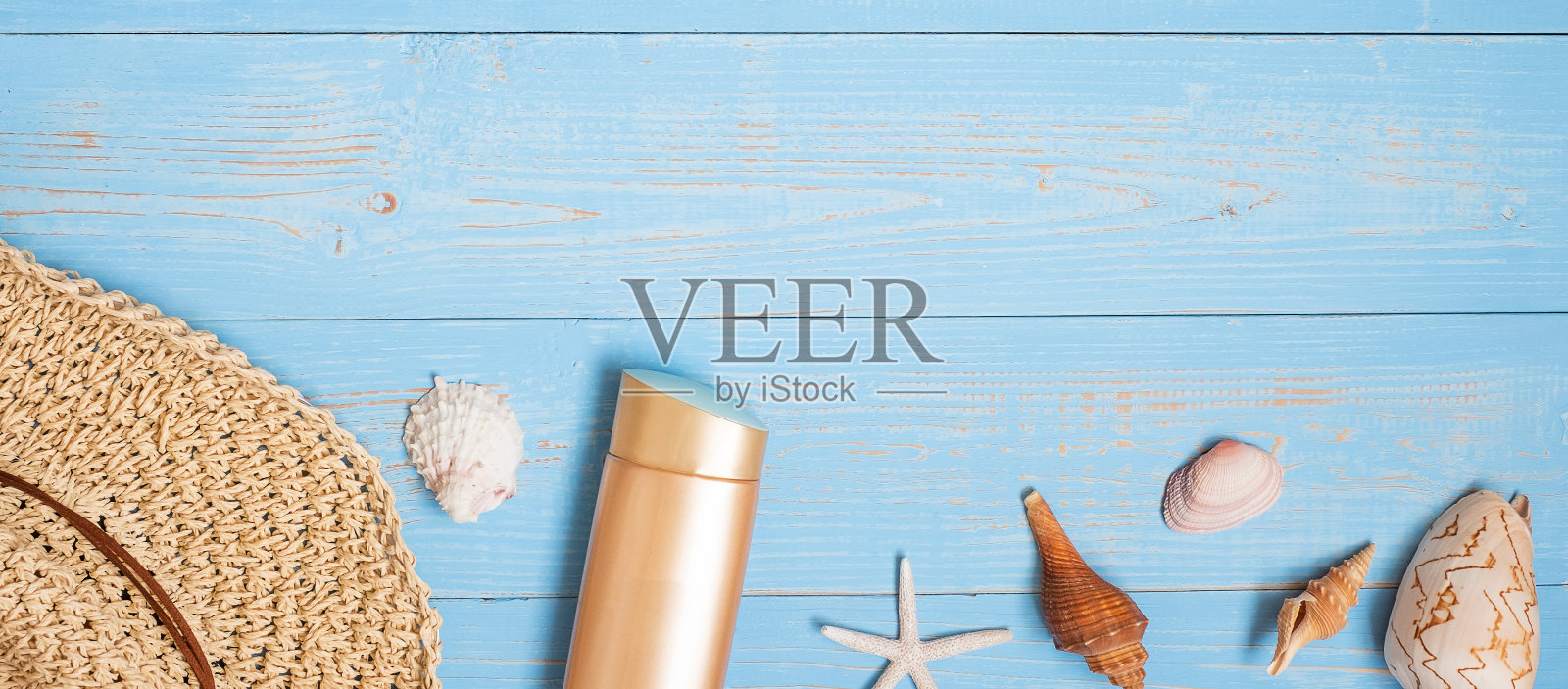 海滩上的配件;帽子，防晒霜，太阳镜，拖鞋和贝壳装饰在蓝色木材，夏季背景和文本拷贝空间。假期，假期和放松的概念照片摄影图片