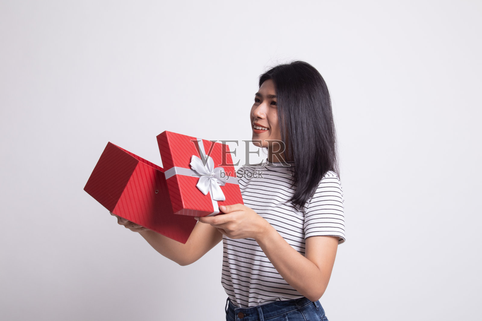 年轻的亚洲女子打开礼品盒。照片摄影图片