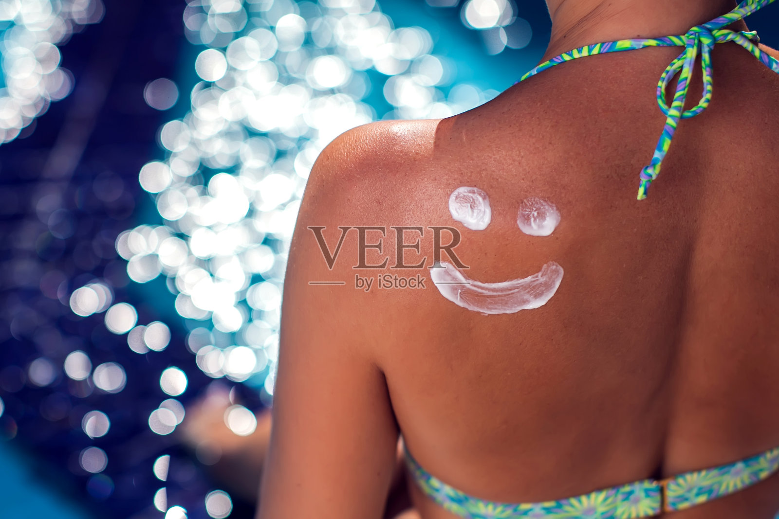 背上涂着防晒霜的女人微笑的样子。人、夏、假、保健理念照片摄影图片